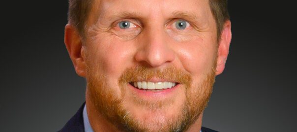 Smiling bearded man in suit and blue shirt